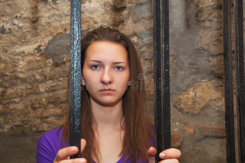 young-woman-looking-behind-bars-30145556.jpg